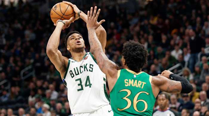 Giannis Antetokounmpo shoots the ball over Marcus Smart